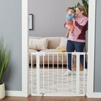 Woman holding baby near a safety gate in a doorway.